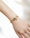 Aria Noir Charm Bracelet on wrist, 18K gold-plated waterproof chain bracelet with black charm and cubic zirconia detail by Yumeira